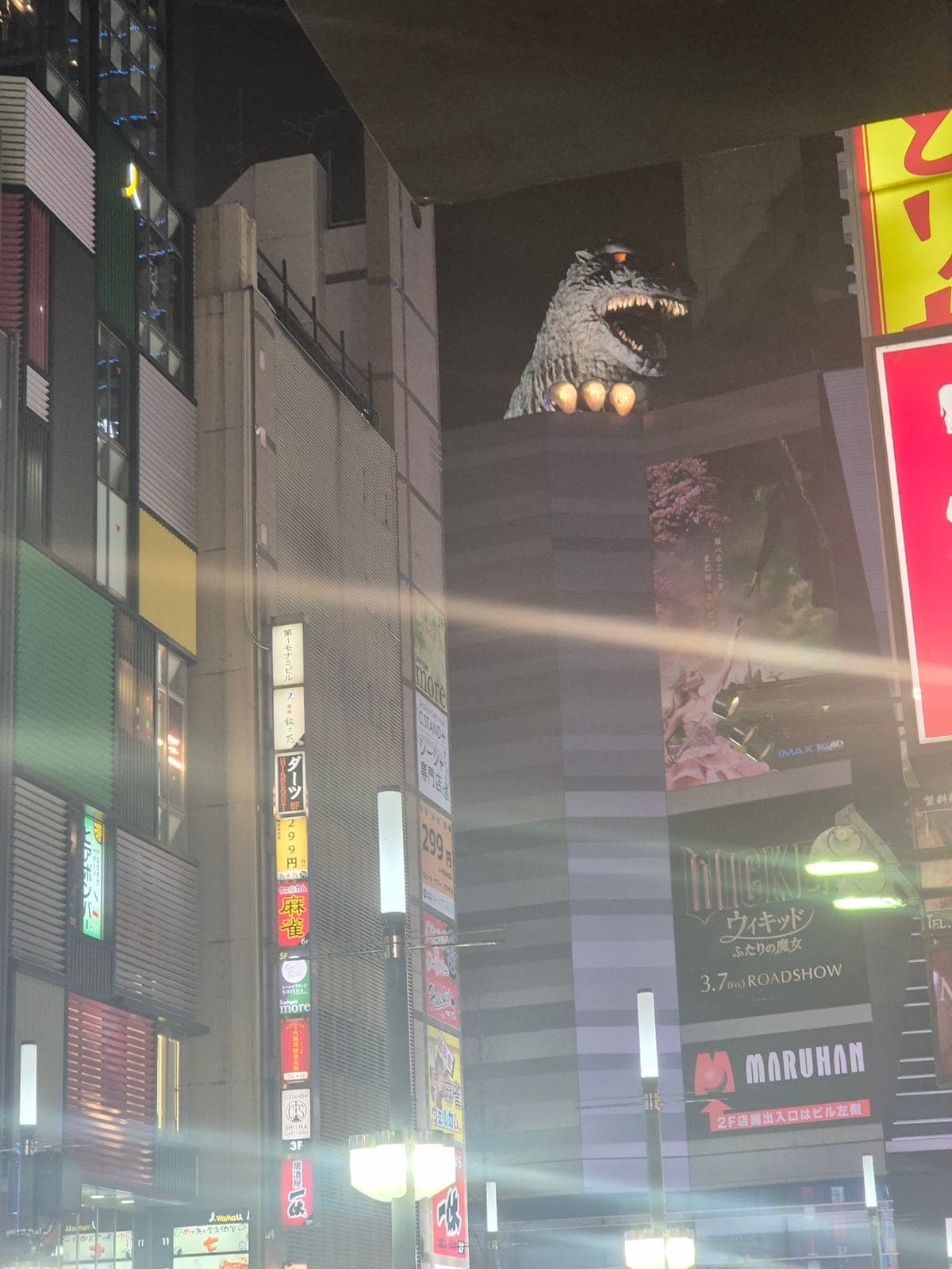 La cabeza de Godzilla de tamaño real sobre el Hotel Gracery Shinjuku, asomándose entre los edificios de Kabukicho