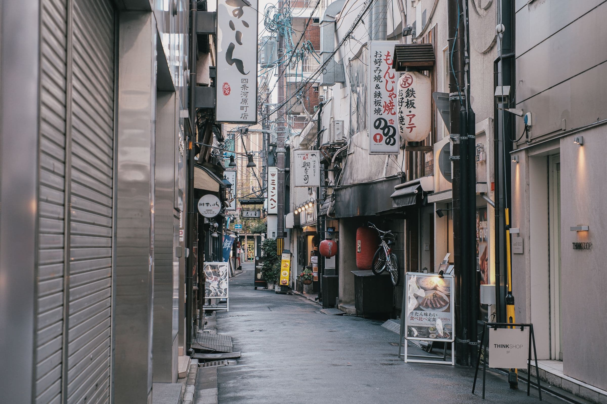 Callejón angosto en Japón con letreros verticales de restaurantes escritos en kanji y kana a ambos lados