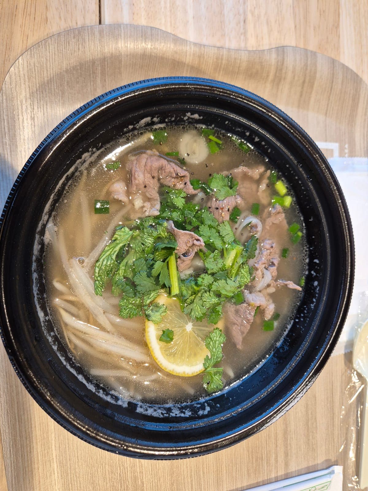 Tazón de pho vietnamita con carne, cilantro y limón, servido en un restaurante dentro de Tokyu Plaza Harajuku