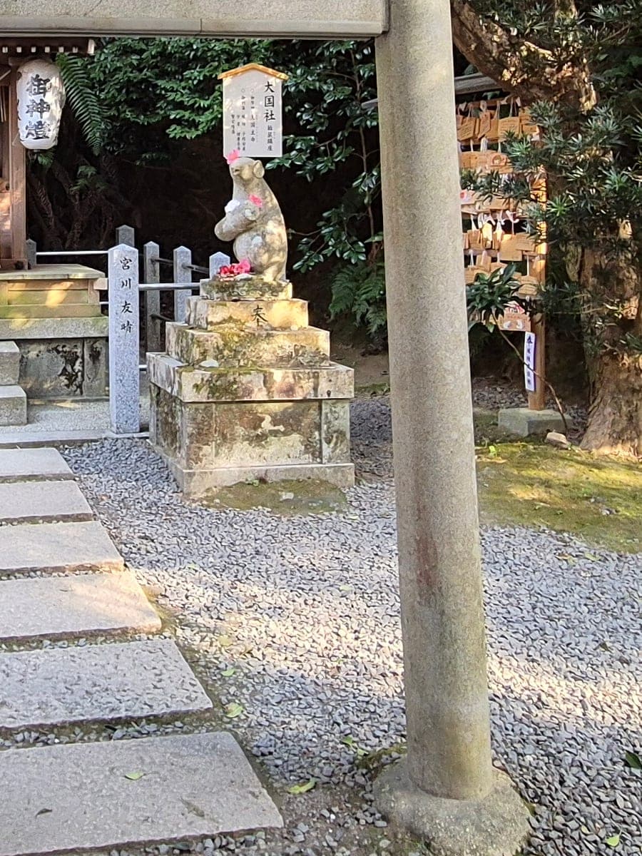 Estatua de piedra de un ratón sobre un pedestal, guardián del templete Ōkuni-sha dentro del santuario Otoyo en Kioto