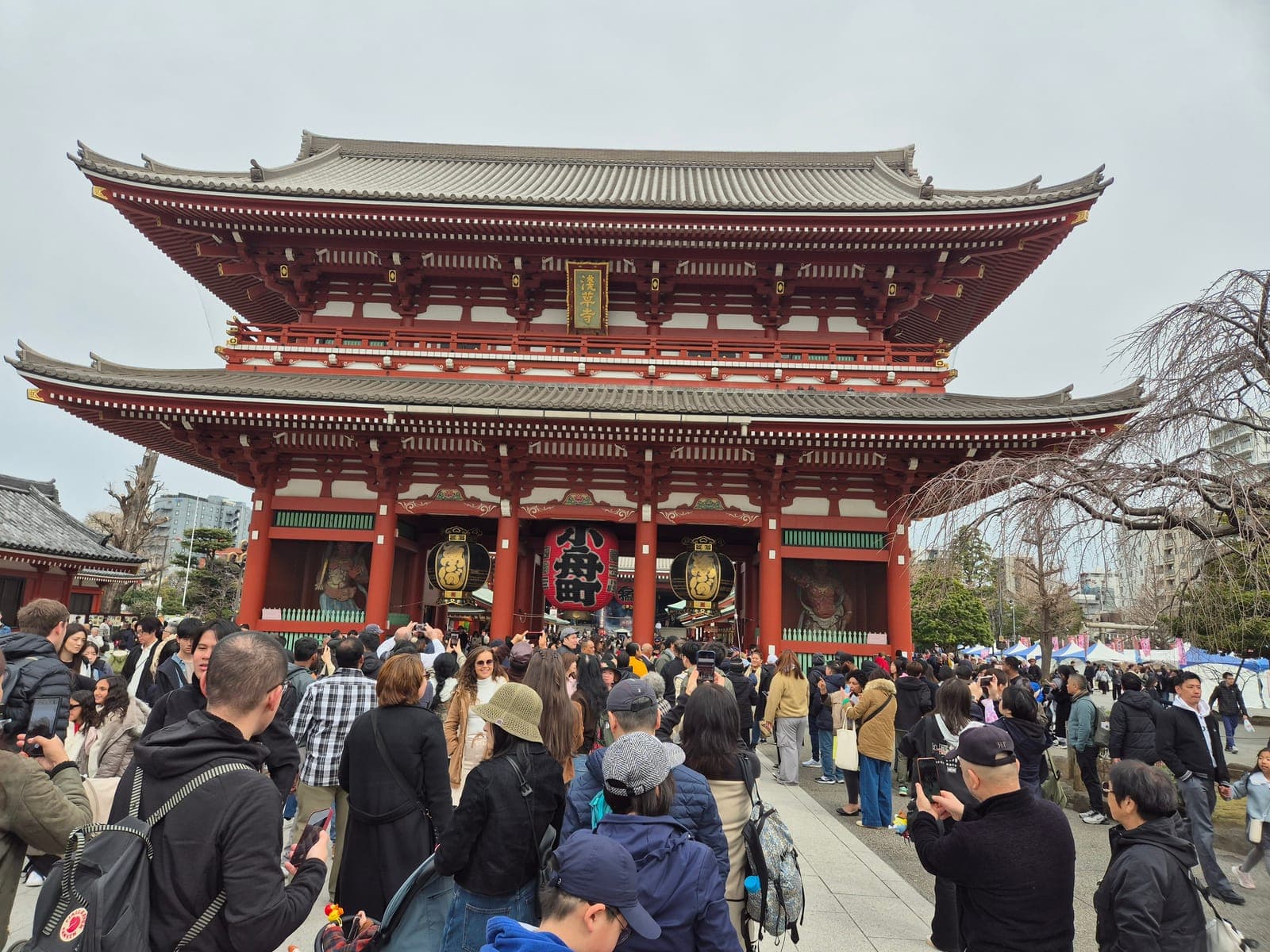 La puerta Hōzōmon del templo Sensō-ji, de dos pisos y color rojo intenso, con su farol gigante y decenas de visitantes