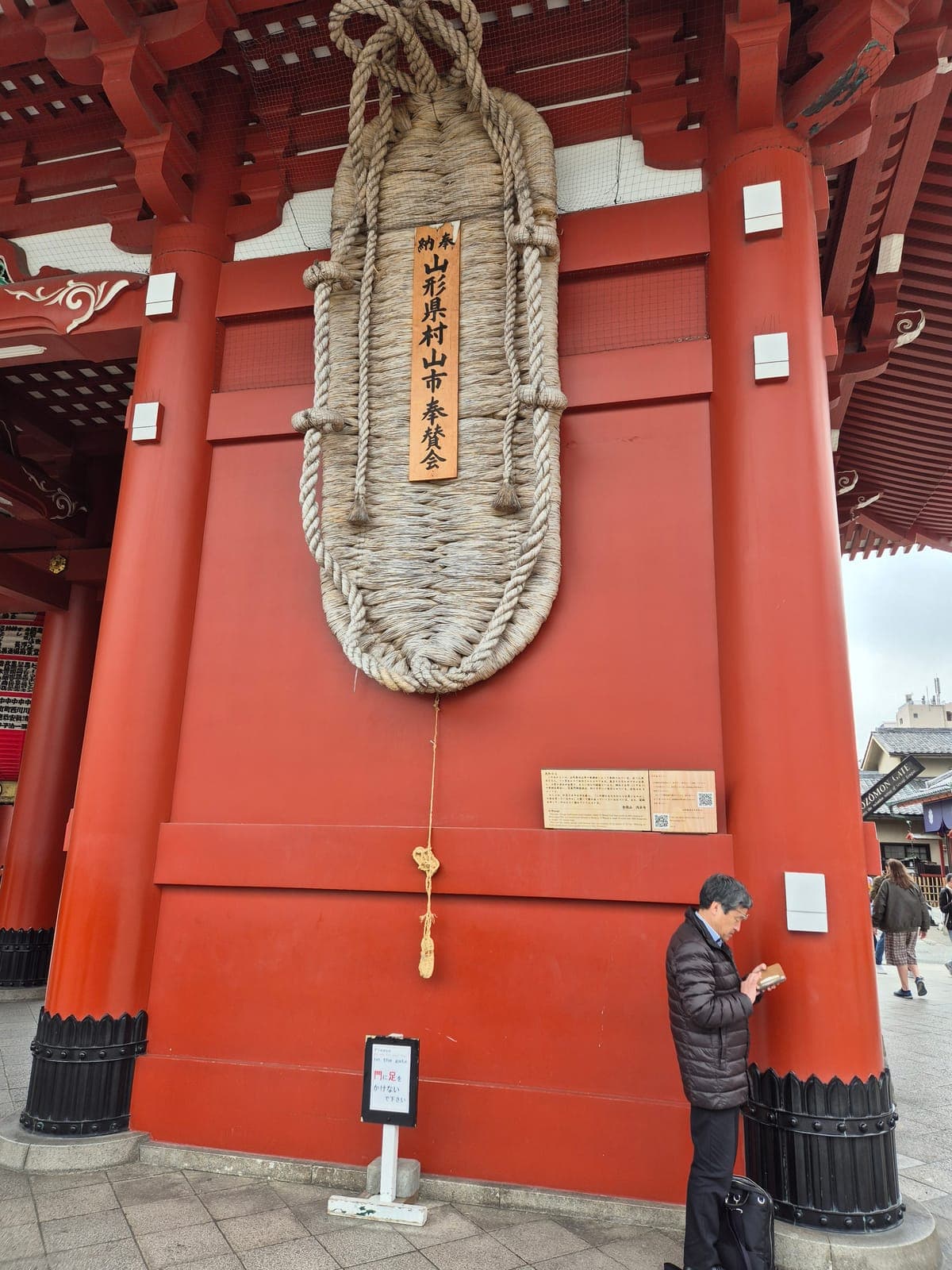 Una ōwaraji, sandalia de paja gigante de 4.5 metros, colgada en un pilar rojo de la puerta Hōzōmon del Sensō-ji