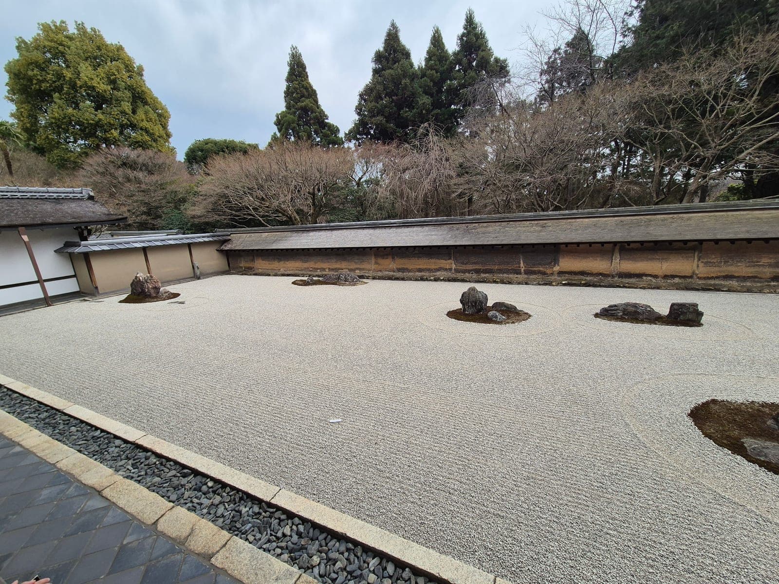 El jardín seco del Ryōan-ji con sus quince rocas sobre grava rastrillada