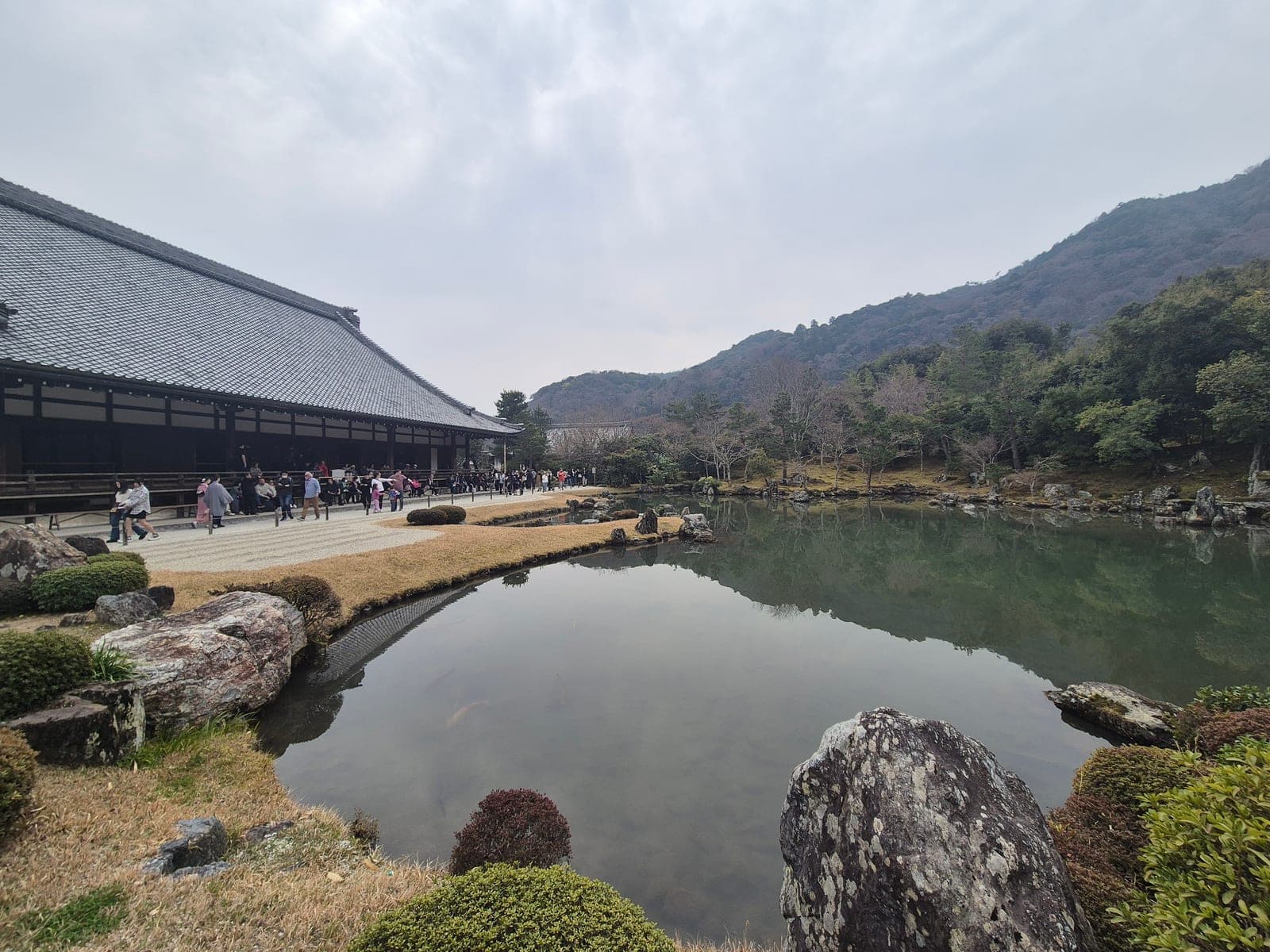 El estanque Sōgen del jardín de Tenryū-ji con el salón del templo a un lado y las montañas de Arashiyama reflejadas en el agua