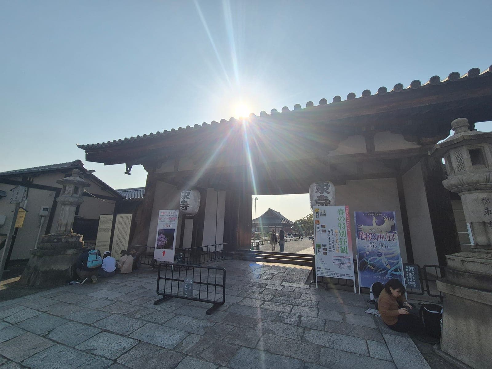 La puerta Keigamon del templo Tō-ji, con sus faroles colgantes y el sol asomando entre las tejas del techo