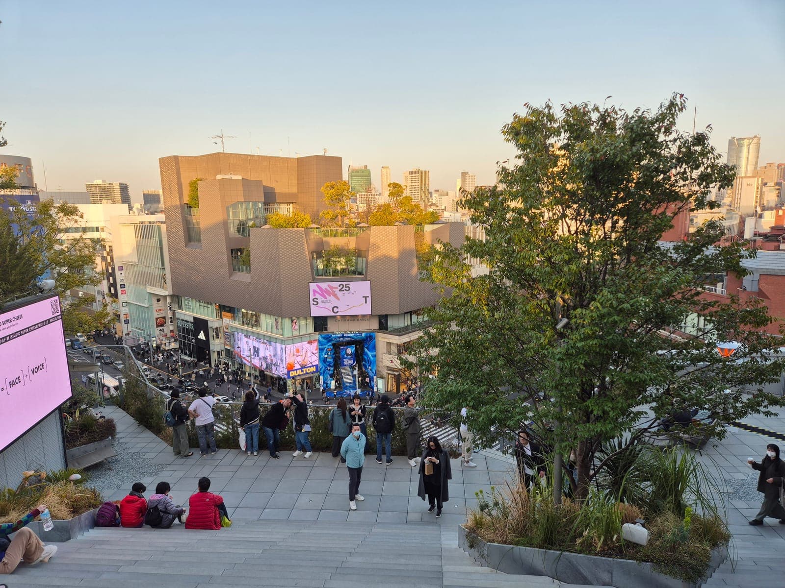 Terraza-jardín en la azotea de un edificio Tokyu Plaza en Harajuku, con árboles y visitantes descansando al atardecer