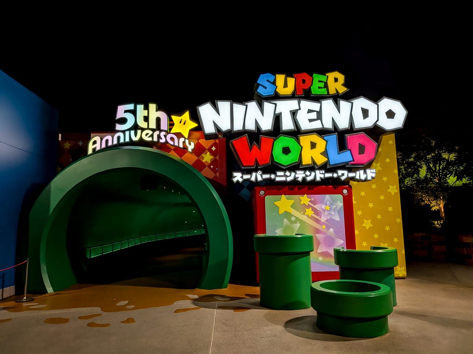 La entrada iluminada de Super Nintendo World con los icónicos tubos verdes de Mario Bros en Universal Studios Japan