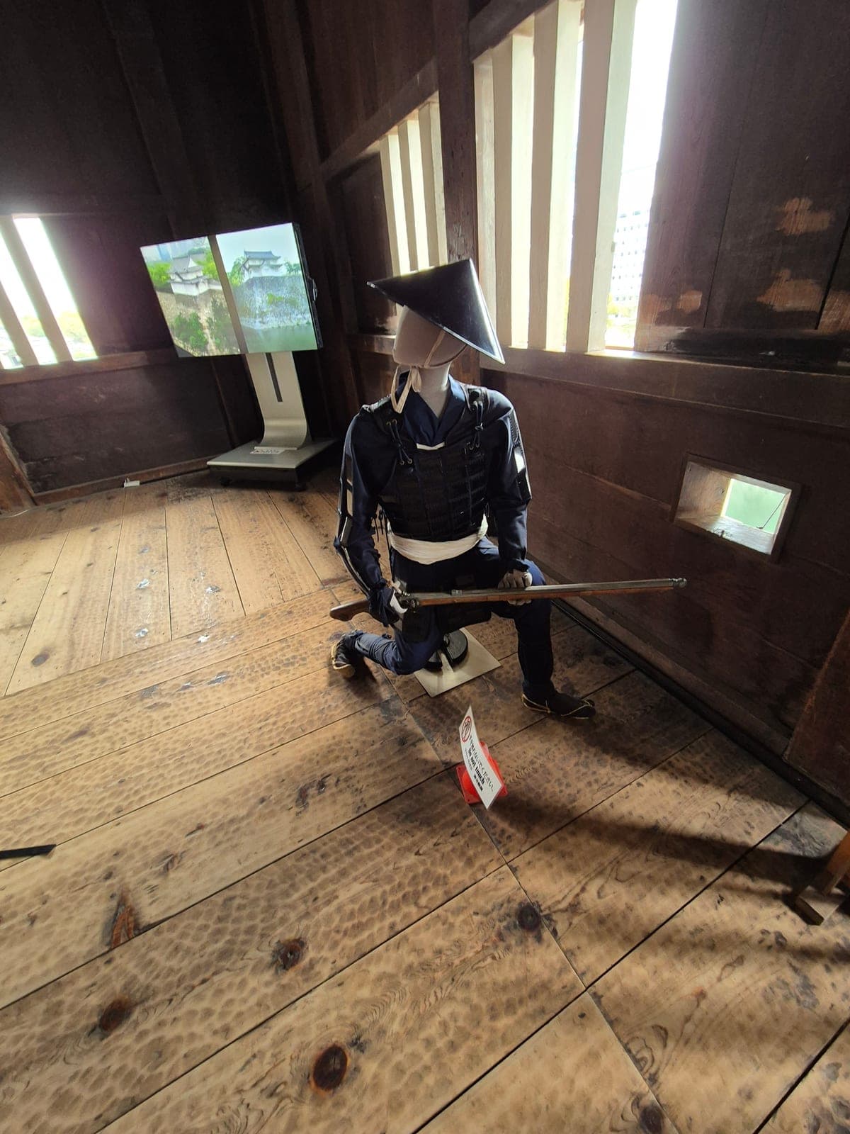 Maniquí con armadura samurái completa y arcabuz, exhibido dentro de la estructura de madera original de Sengan-yagura en el Castillo de Osaka