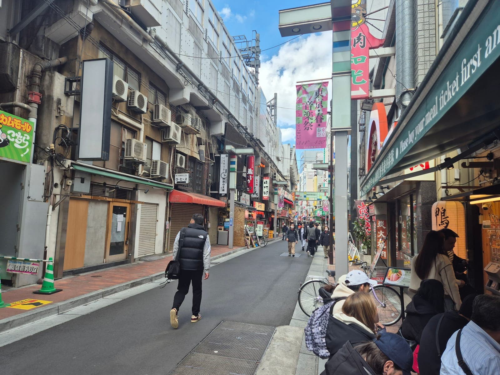 Una de las calles laterales de Ameyoko en Ueno, con letreros japoneses, aires acondicionados colgantes y locales pequeños