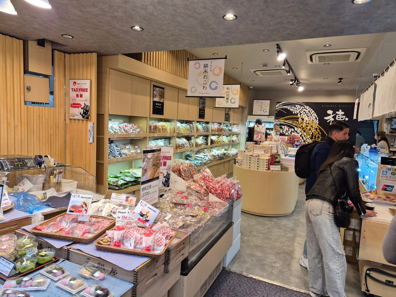 Interior de una tienda de dulces japoneses en Kuromon Ichiba con bandejas de mochi, dorayaki y botanas variadas
