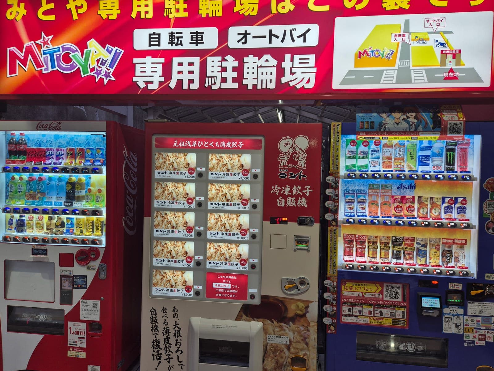 Máquina expendedora roja que vende paquetes de gyoza congelados, junto a un refrigerador de bebidas en una calle de Asakusa