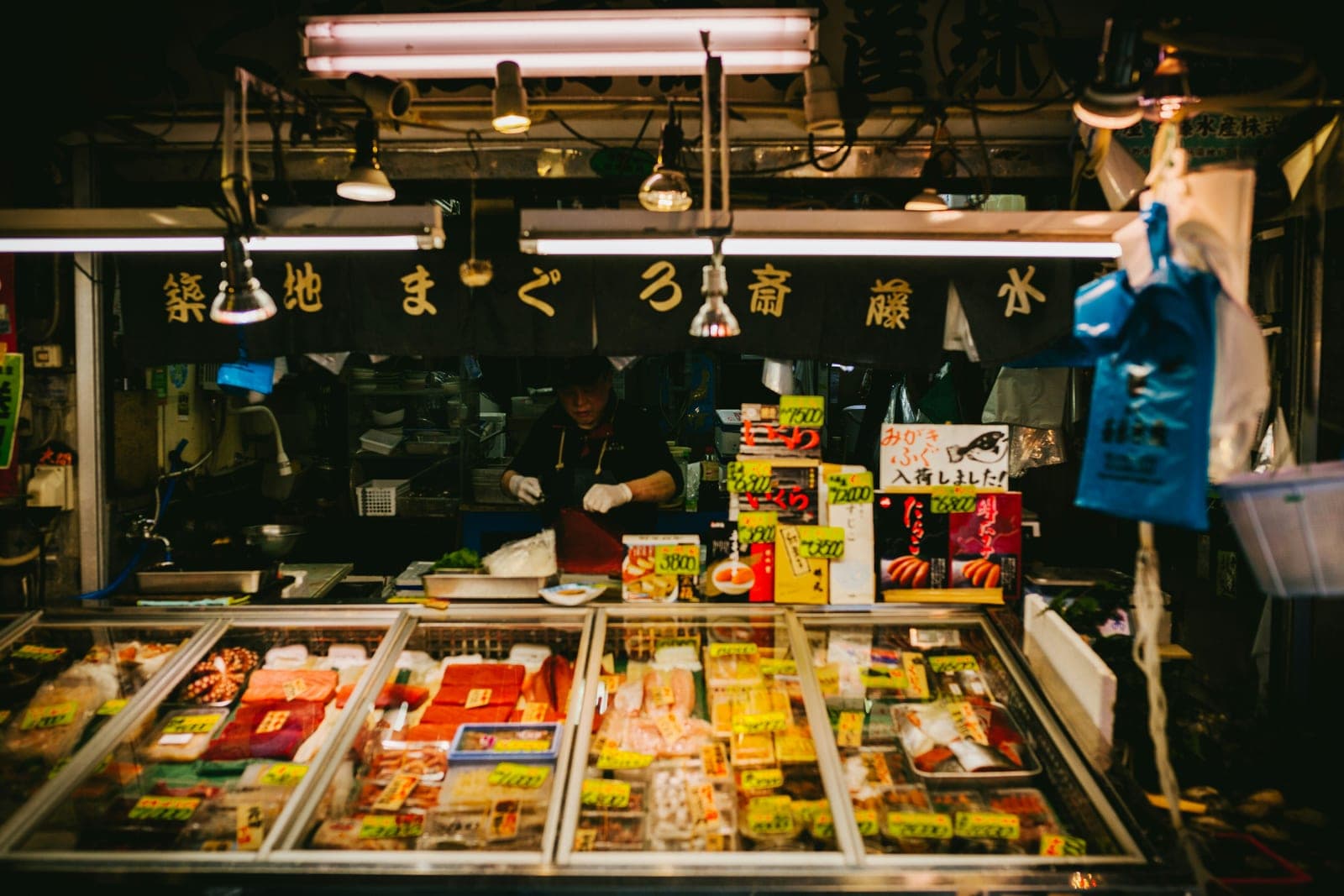 Vitrina refrigerada de un puesto en Tsukiji con cortes de atún, salmón y otros mariscos frescos etiquetados con su precio