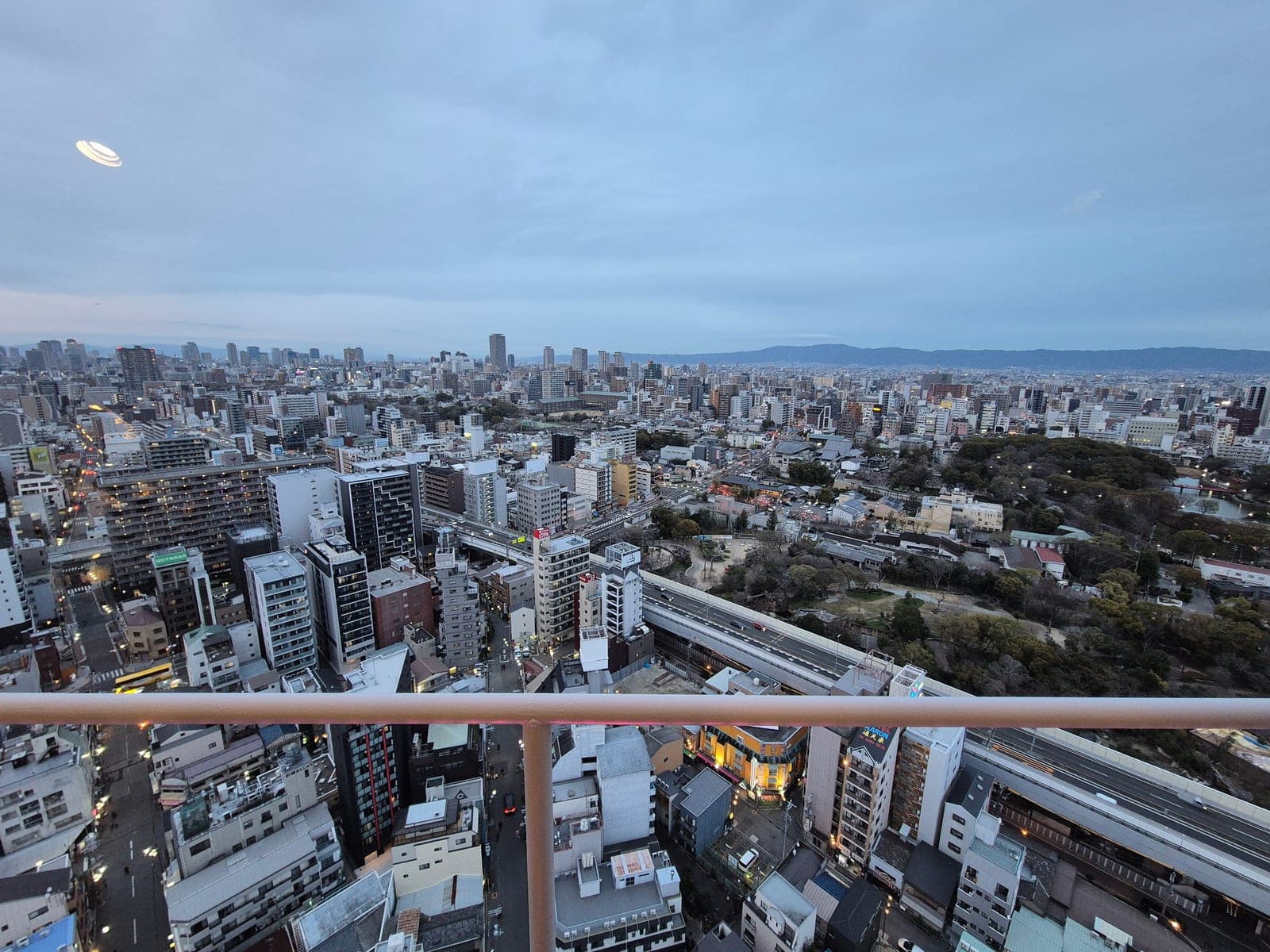 Panorama de Osaka al atardecer desde el mirador de la torre Tsutenkaku, con el parque de Tennōji a la derecha y el centro de la ciudad al fondo