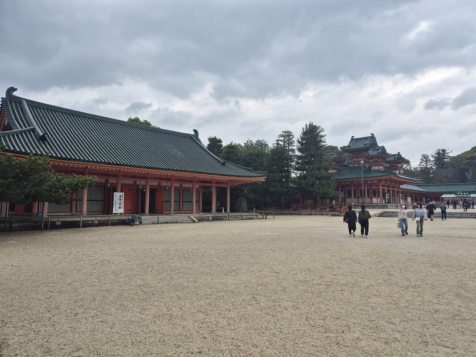 El patio de grava del santuario Heian con los pabellones bermellón y techos verdes de la réplica del palacio Heian