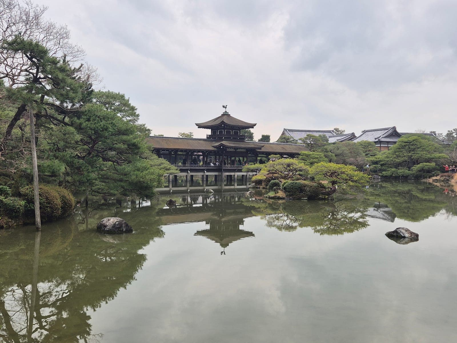 El puente cubierto Taihei-kaku sobre el estanque de los jardines Shin'en del santuario Heian, con su pabellón reflejado en el agua