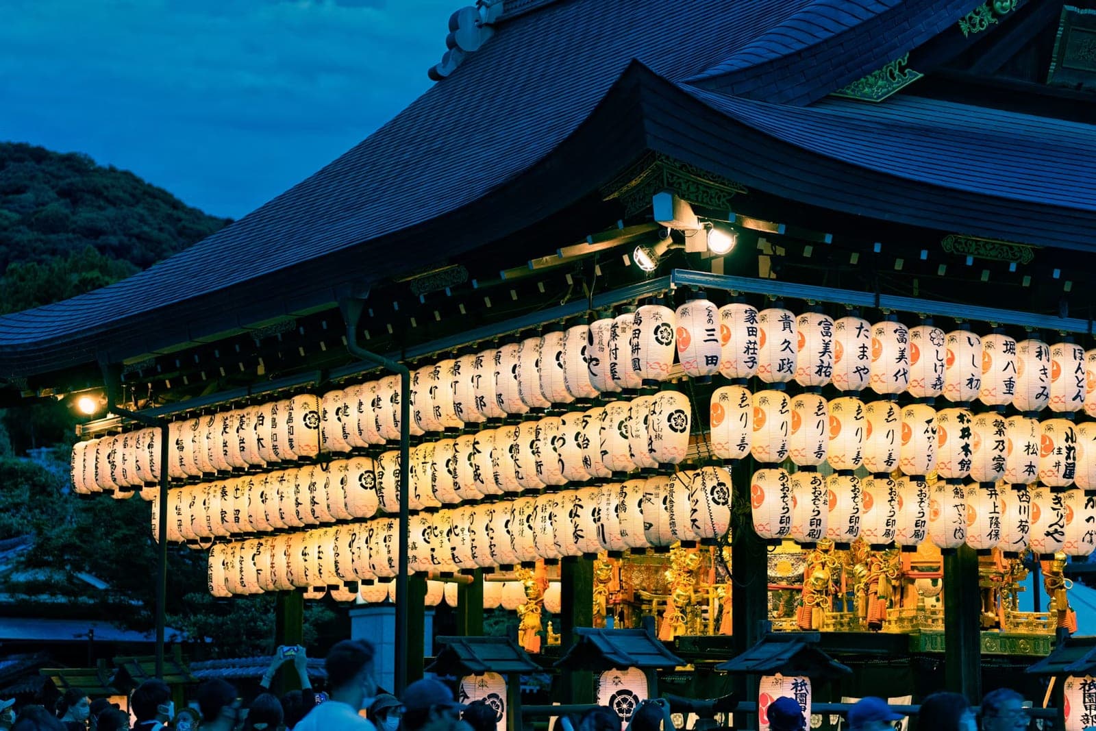 El escenario de danza del santuario Yasaka de noche, cubierto de linternas de papel encendidas con nombres de donantes