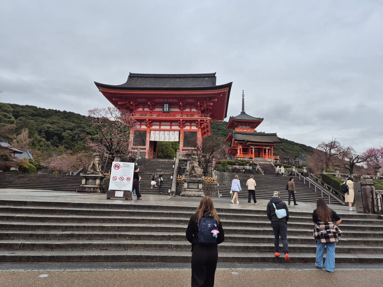 La puerta Niomon y la pagoda de tres pisos del templo Kiyomizu-dera al pie de la escalinata de entrada, con visitantes subiendo
