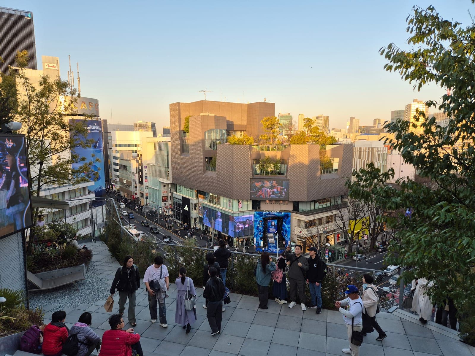 La zona de moda de Omotesandō en Harajuku, Tokio, al atardecer, con gente paseando y el edificio Tokyu Plaza al fondo