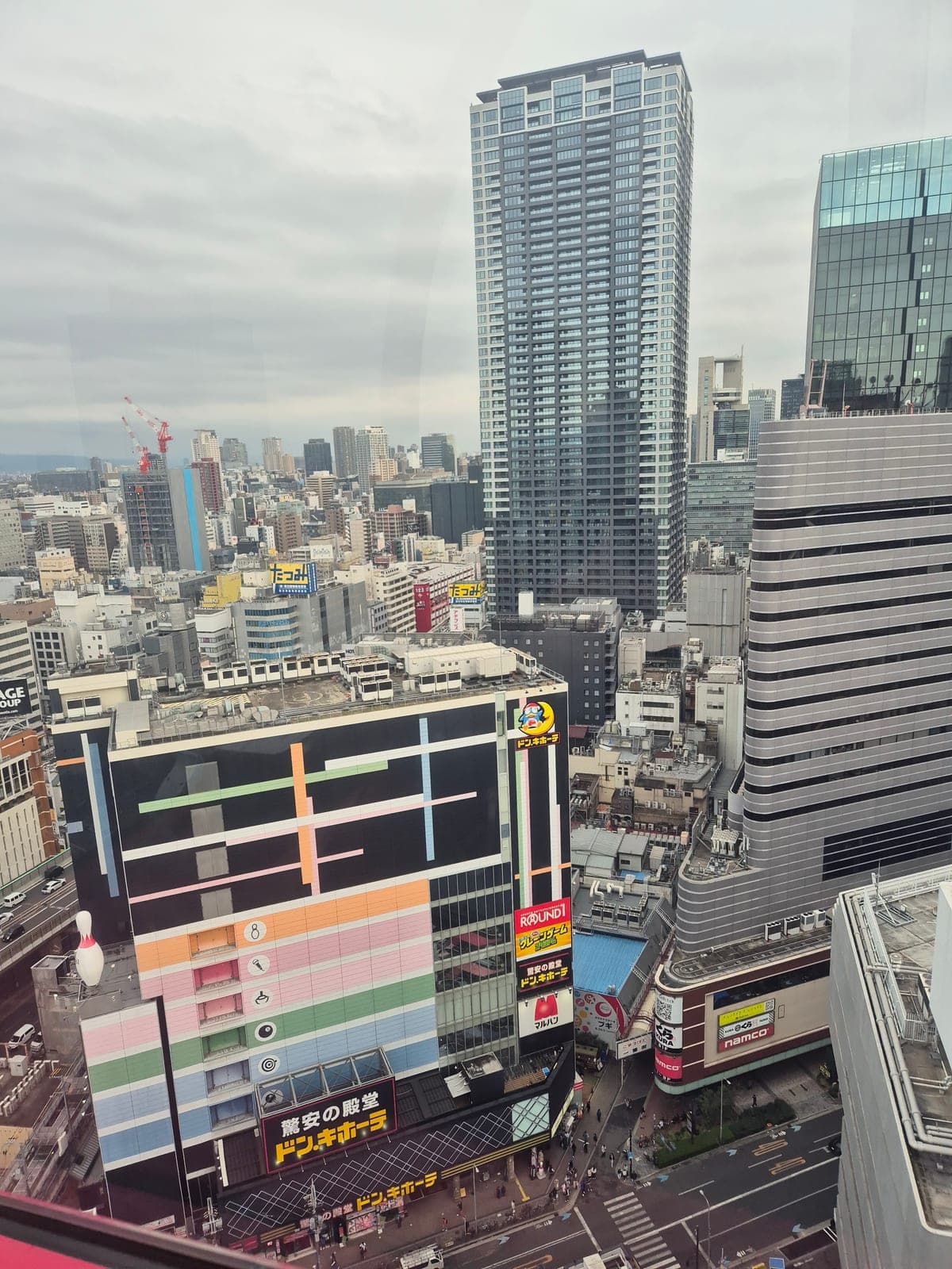Vista desde la rueda de la fortuna de HEP FIVE hacia la tienda Don Quijote en Umeda, Osaka, con su fachada de cuadros de colores